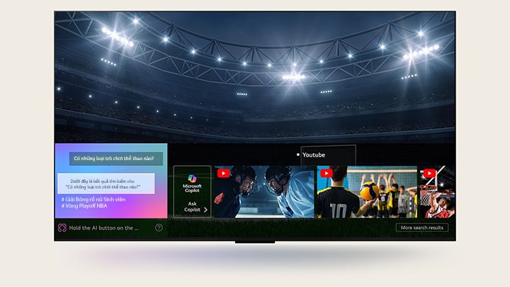 Màn hình TV LG hiển thị cách AI Search hoạt động. Một cửa sổ chat nhỏ mở ra, cho thấy người dùng đặt câu hỏi về các trận đấu thể thao có sẵn. AI Search phản hồi qua cuộc trò chuyện và hiển thị hình thu nhỏ của các nội dung phù hợp. Đồng thời, trên màn hình cũng xuất hiện gợi ý đặt câu hỏi cho Microsoft Copilot.