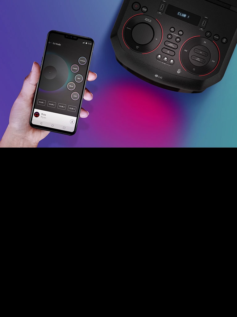 Bàn tay đang cầm một chiếc điện thoại thông minh cạnh LG XBOOM theo góc nhìn từ phía trên.