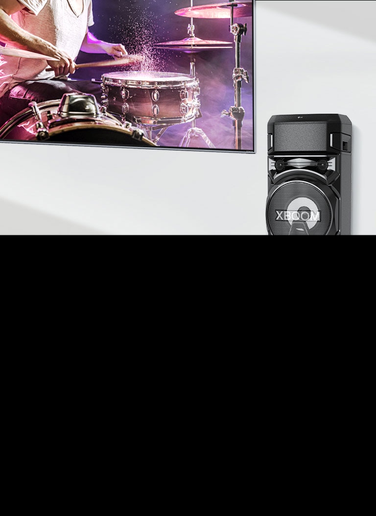 Một chiếc TV treo trên tường với loa LG XBOOM đặt ở bên phải.