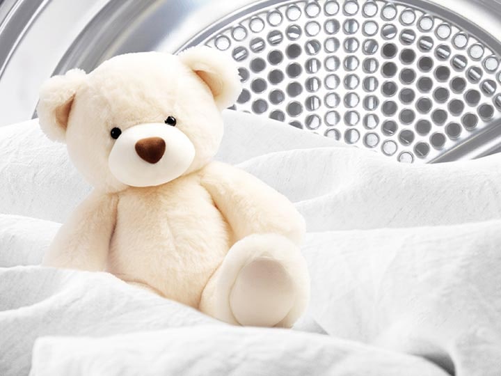 Image of a blanket and teddy bear inside an LG dryer