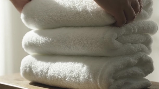 Người dùng chạm vào quần áo sau khi sấy, minh họa độ mềm của vải sau chu trình AI Dry.