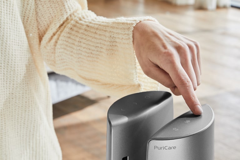 Một phụ nữ chạm vào phía trên máy bằng ngón tay.