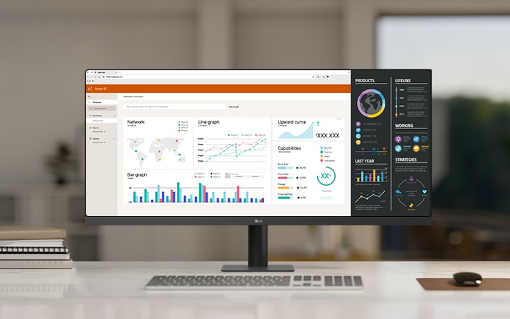 LG ultra-wide monitor trên bàn làm việc màu trắng trong một văn phòng hiện đại, hiển thị nhiều bảng điều khiển và đồ thị dữ liệu giúp nâng cao năng suất và cho phép đa nhiệm.