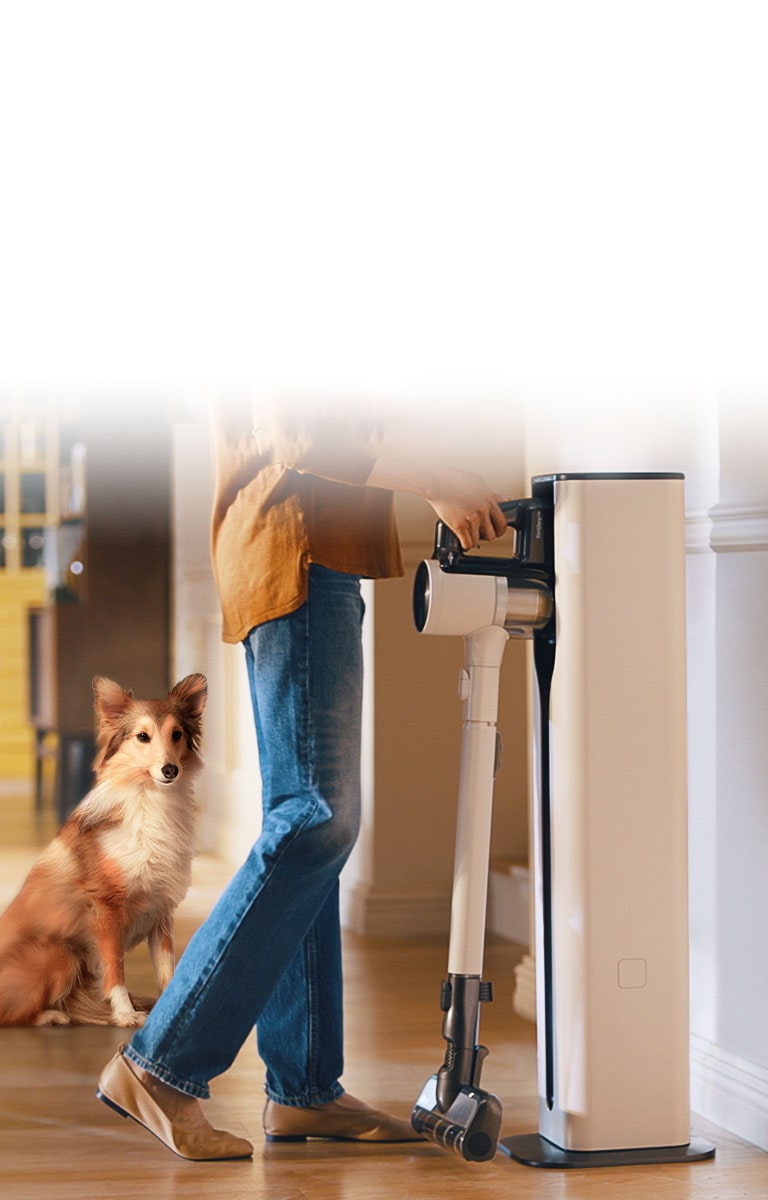 Một phụ nữ đang đặt máy hút bụi Cordzero™ vào tháp sạc.
