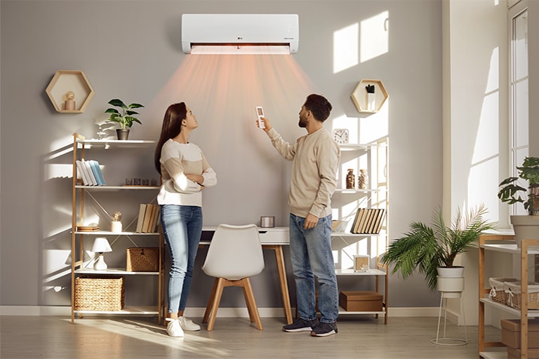 Một người đàn ông và một người phụ nữ được sưởi ấm với làn gió từ máy sưởi
