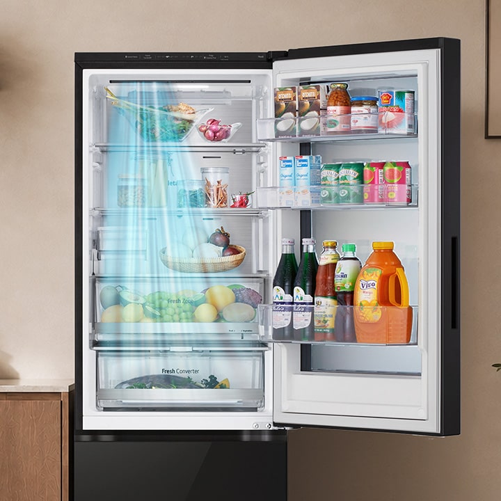 Luồng khí lạnh chảy dọc phía trước tủ lạnh đang mở như một tấm màn, lướt qua các ngăn cửa và đồ uống.