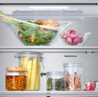 Cận cảnh tủ lạnh LG ngăn đá dưới với nhiều loại rau củ tươi ngon và thực phẩm bảo quản trong hộp thủy tinh.