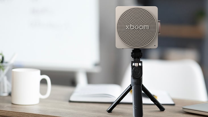 Grey-colored LG xboom mini on a tripod, a mini bluetooth speaker with an iconic design and a universal mount for accessories