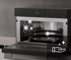 Image of an open cooking appliance with interior lights on; the icon shows a hand, representing cleaning.