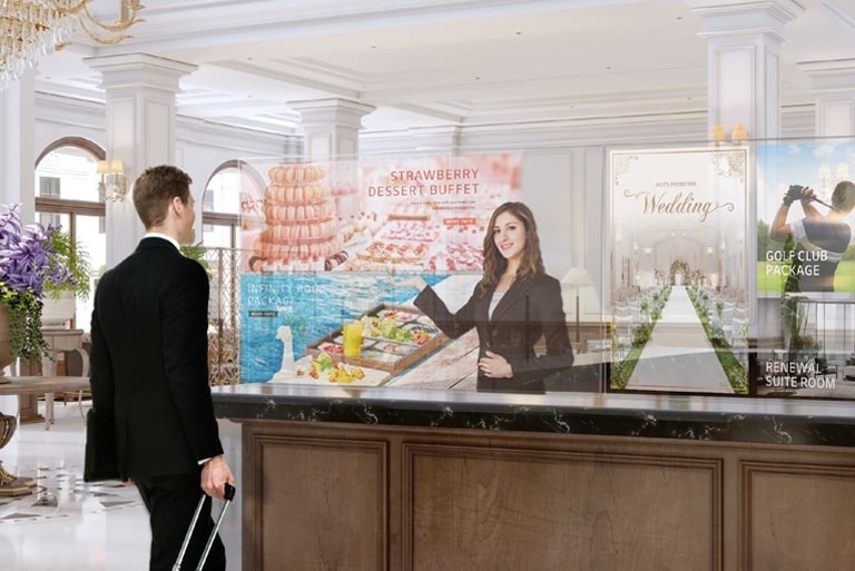 A man is being shown information and photos of the dessert menu on the transparent OLED screens.