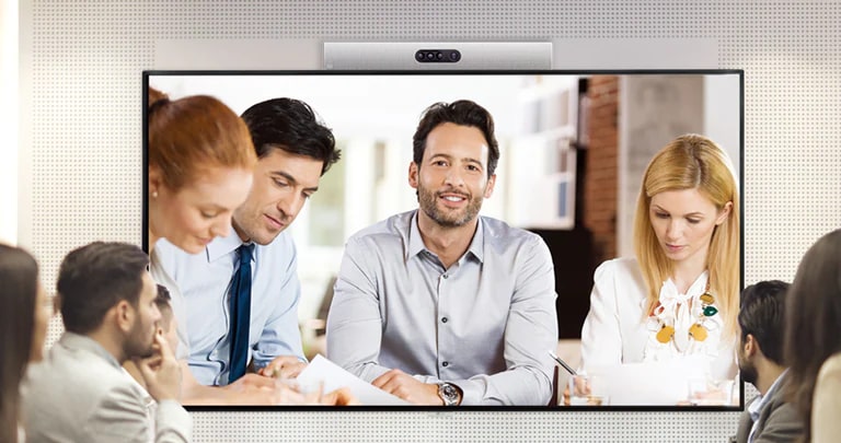 A video conference is being held as people are screened on signage installed on the wall.