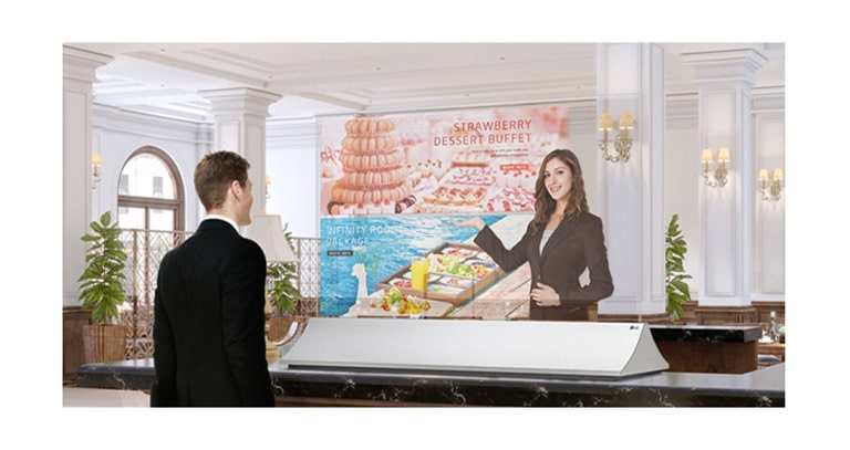 A man is getting information through the Transparent OLED screen showing photos of the dessert menu.