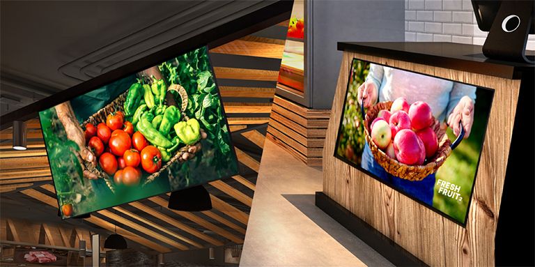 One UL3Q is installed on the store ceiling with a Face Down tilt, and the other is mounted below the counter with a Face Up tilt, both displaying content.