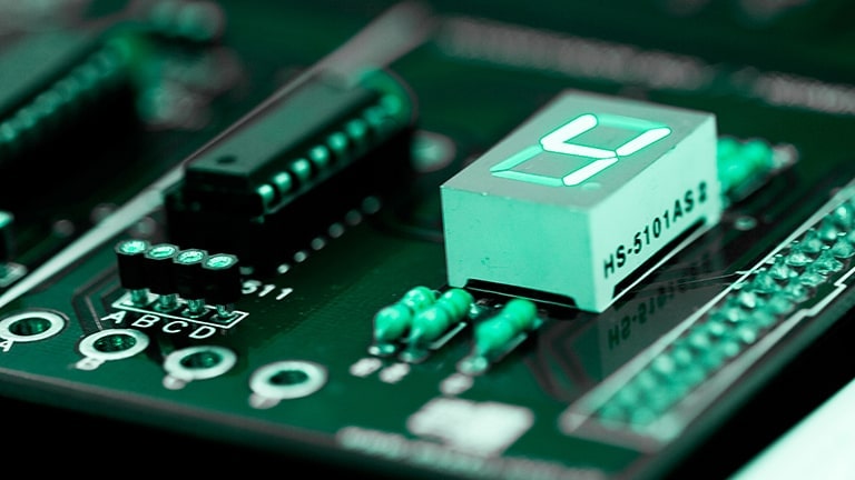 Um circuito complexo colorido em verde apresenta um componente retangular conectado, exibindo em negrito o número quatro.