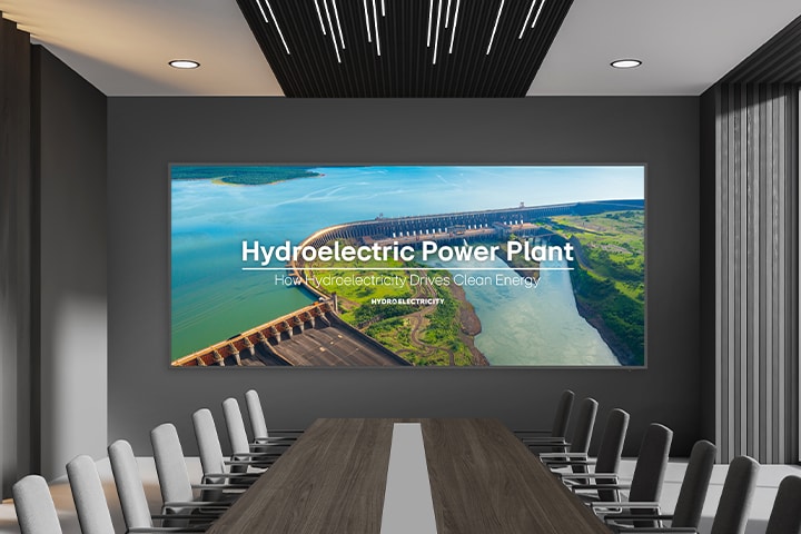 Uma ampla tela está instalada na parede da espaçosa sala de conferências, e a apresentação é exibida de forma destacada e clara.