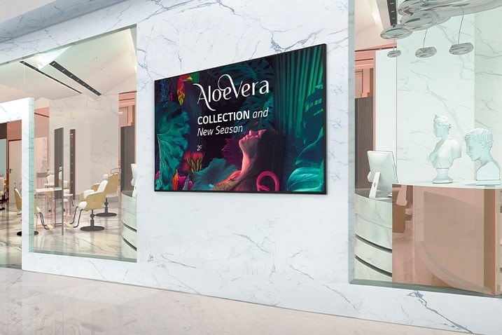 Um painel de sinalização instalado na parede interna de um shopping exibe anúncios de forma vívida.