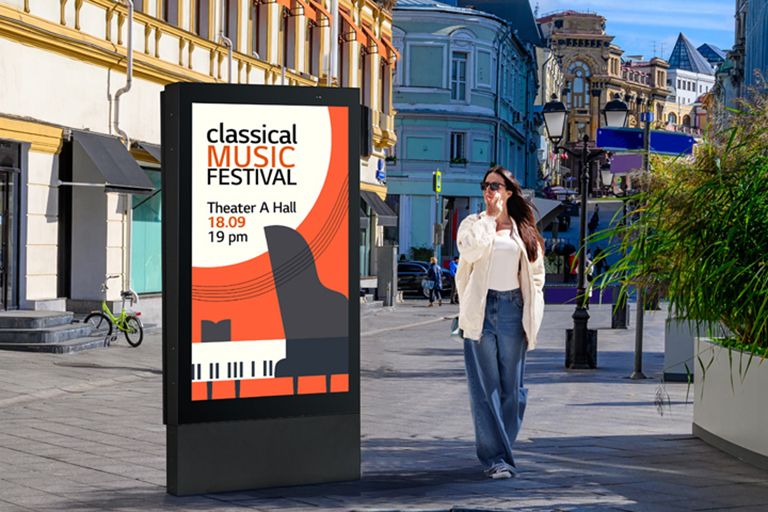 Um display de grande porte está instalado na rua, e uma mulher observa um anúncio com qualidade vívida na tela.