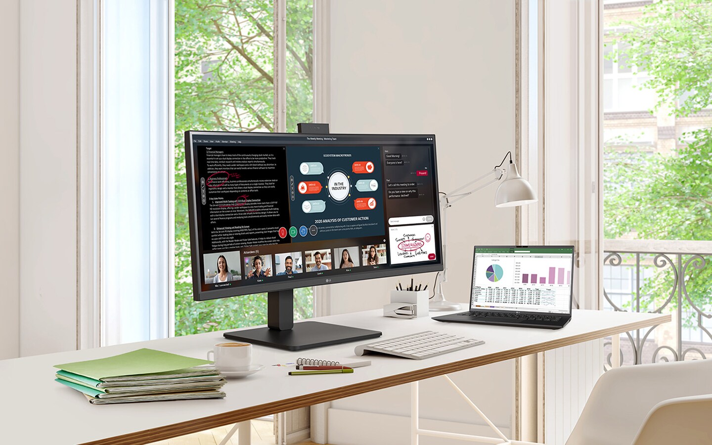 Home office desk with monitor, laptop, and books by the window