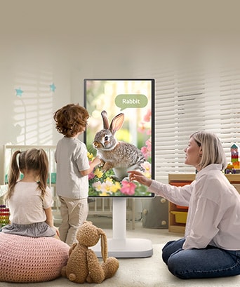 Cette image montre une femme et trois enfants jouant avec un LG Smart Monitor Swing.