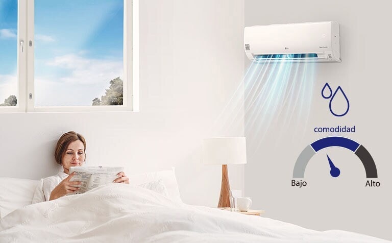 Imagen de una mujer leyendo en la cama con el aire acondicionado encendido.