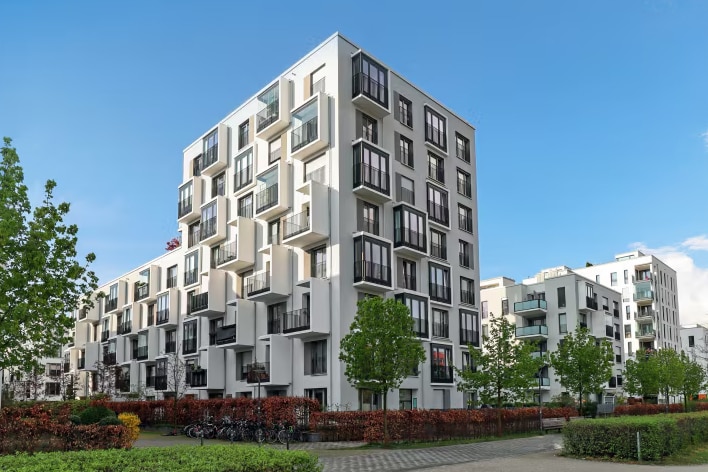 Complejo de apartamentos multifamiliares moderno con árboles y áreas verdes