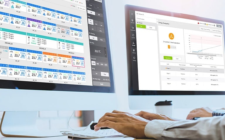 Ein Bild einer Person, die zwei Monitore für eine effiziente Energieverwaltung nutzt.