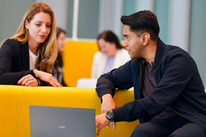 Geschäftsleute besprechen eine digitale Lösung mit einem LG Laptop in einer modernen Arbeitsumgebung.