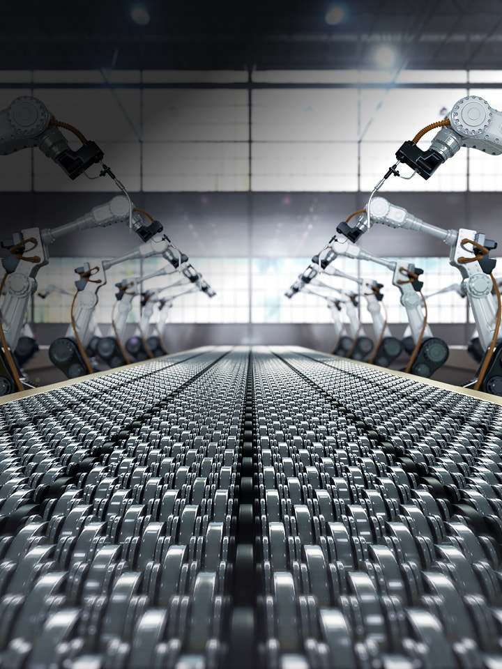 Eine Reihe von Roboterarmen, die entlang beider Seiten eines Förderbandes in einer großen Industriefabrik positioniert sind und nach innen zur Produktionslinie gerichtet sind.