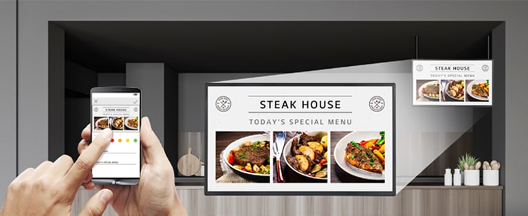 Ein Gastronom nutzt einfach ein Mobiltelefon, um das Tagesmenü auf der Anzeige mit den angebotenen Speisen zu erstellen.