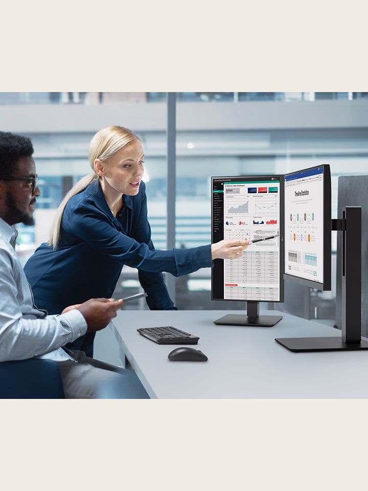Two male and female employees discuss while looking at the monitor in the office.