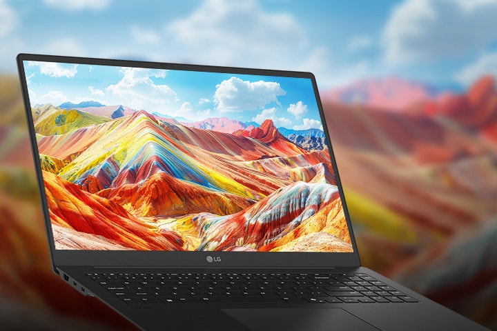 Ein Laptop, der auf seinem Bildschirm eine lebendige und farbenfrohe Landschaft mit leuchtenden Bergen zeigt, wobei die hohe Auflösung und die satte Farbwiedergabe besonders hervorstechen. Im Hintergrund ist eine unscharfe Version derselben Landschaft zu sehen, um die Aufmerksamkeit auf die Bildschirmqualität zu lenken.