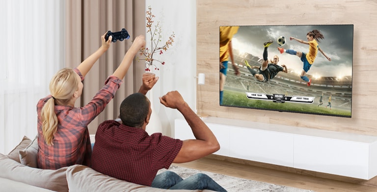 Un homme et une femme jouent à des jeux et la scène du jeu affichée sur l’écran de TV est représentée de façon réaliste.