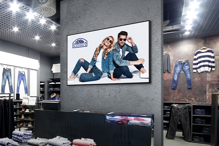 Un écran d’affichage est installé sur le mur central du magasin de vêtements, affichant des publicités d’une clarté saisissante.