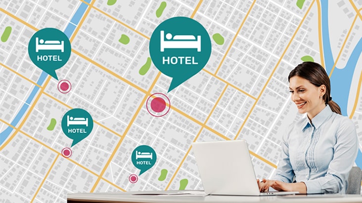 Une femme assise à son bureau utilise son ordinateur portable pour gérer les TVs de l’hôtel à différents endroits.