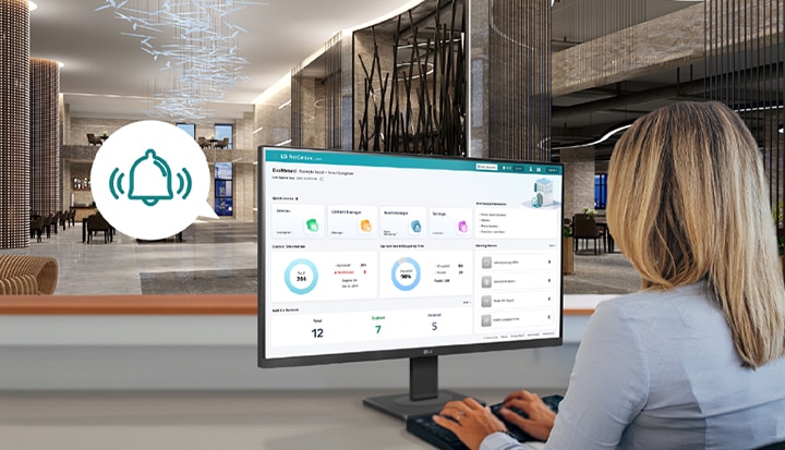 L’image montre un membre du personnel de l’hôtel surveillant l’écran du tableau de bord fourni par LG Pro :Centric Cloud.