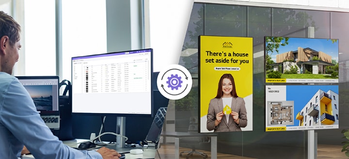 L’image montre des publicités immobilières et du contenu affiché sur des écrans orientés vers la fenêtre à droite, tandis qu’un opérateur à gauche gère à distance la signalétique à l’aide de LG SuperSign Cloud.