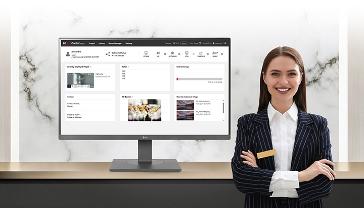L’image montre un moniteur affichant LG Pro :Centric Direct, aux côtés d'une hôtelière souriante.
