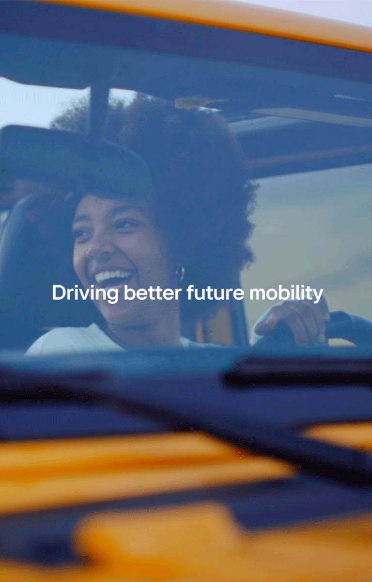 An image of a woman smiling happily while driving with her friends, with the words "Driving better future mobility" above it.