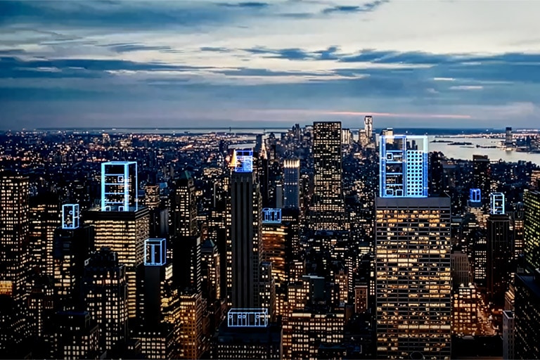 Illuminated night cityscape with digital blue highlights on various buildings, illustrating system integration.