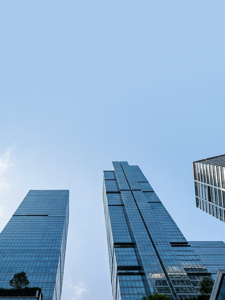 Low-angle view of modern glass skyscrapers against a blue sky, representing LG HVAC Solutions.