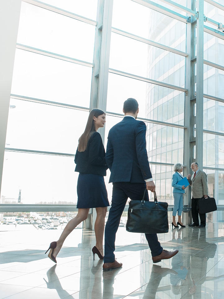 LG integrated solutions for government spaces visual showing modern office architecture with glass walls and professionals collaborating, highlighting efficient LG business technologies for public sectors.