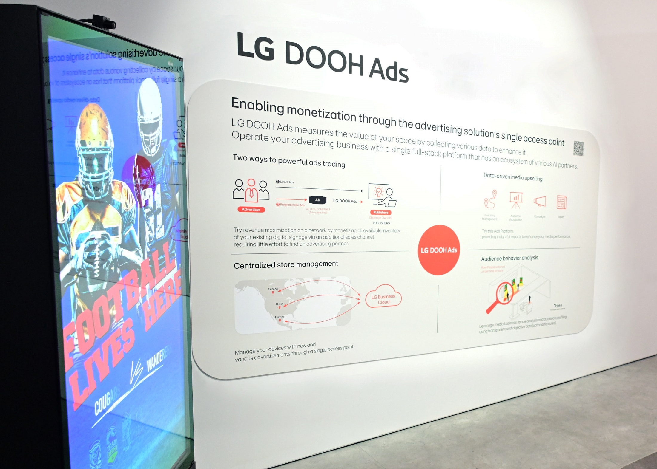 LG DOOH Ads display at an exhibition, featuring a digital advertising screen showing sports content and a wall panel explaining LG’s digital out-of-home advertising solutions and benefits.