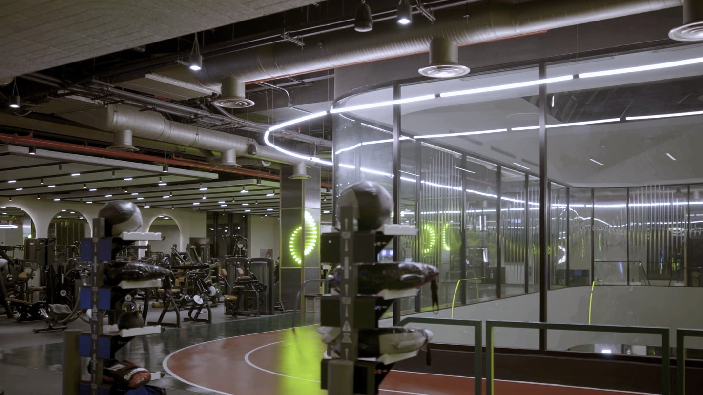 Modern fitness center interior with cardio machines, medicine balls, and curved running track