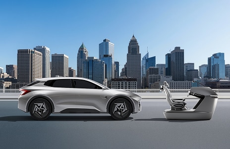 Family in a bright living room using a laptop under a wall-mounted air conditioner with cool air flowing.