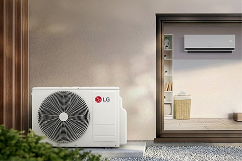 Family in a bright living room using a laptop under a wall-mounted air conditioner with cool air flowing.