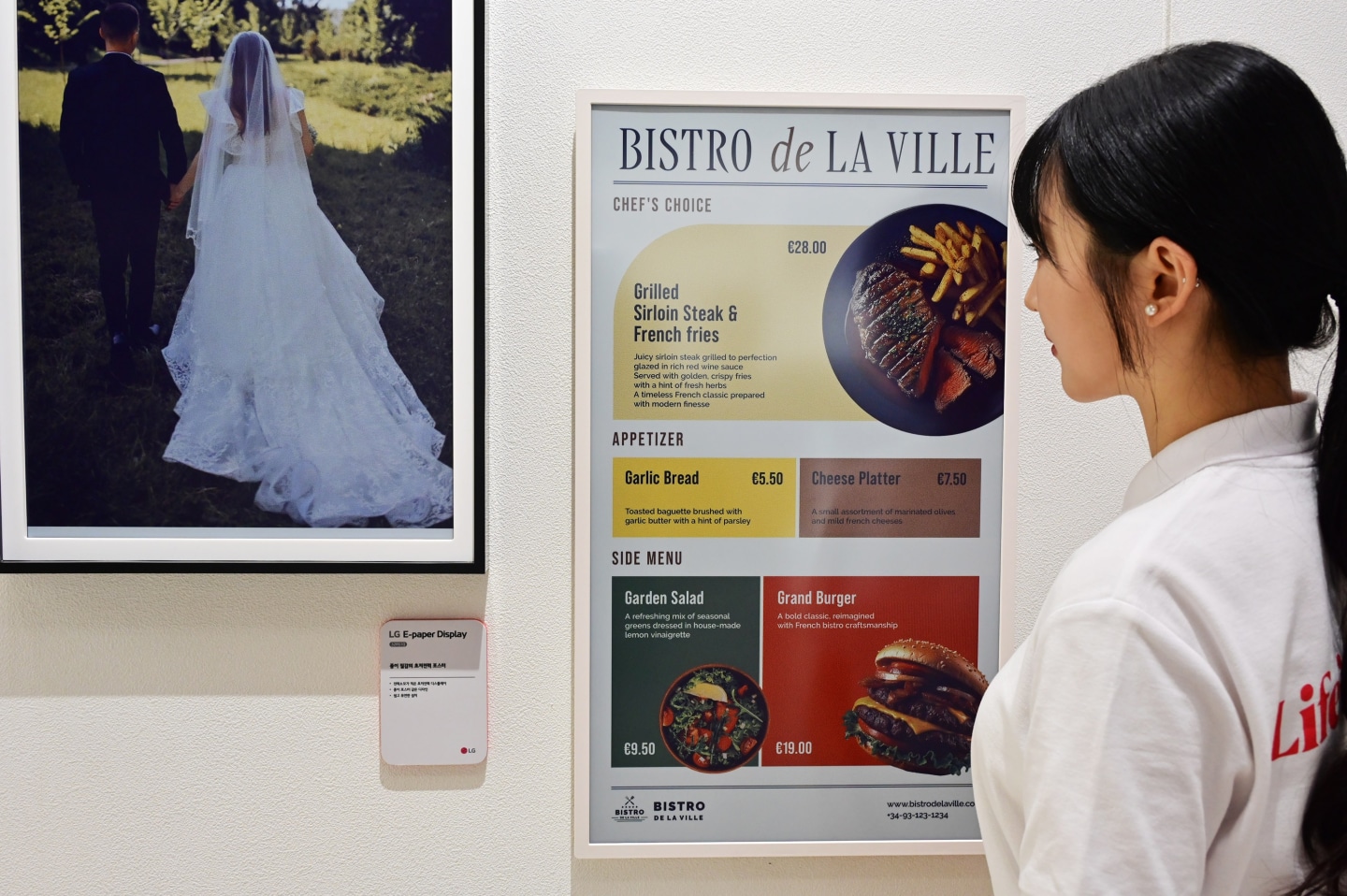 A woman views a restaurant menu on an LG E-Paper Display.