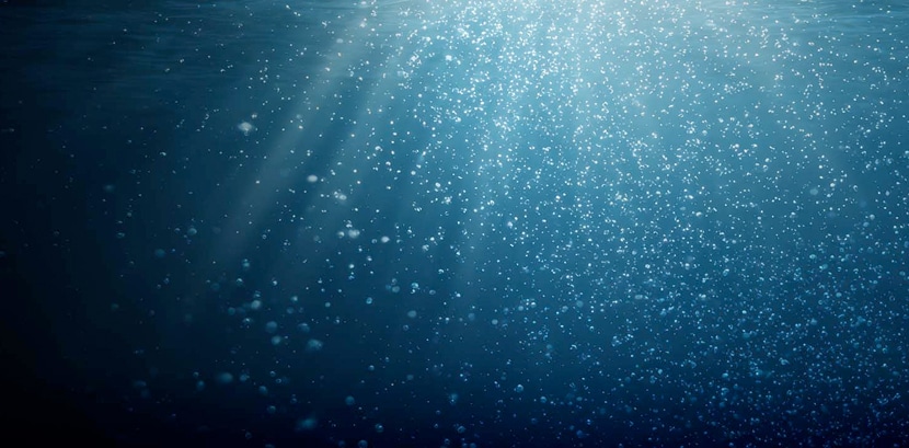 light rays filtering through water with suspended particles.