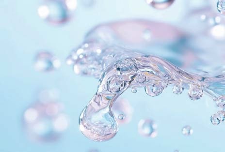 Clear water droplet with bubbles on blue background