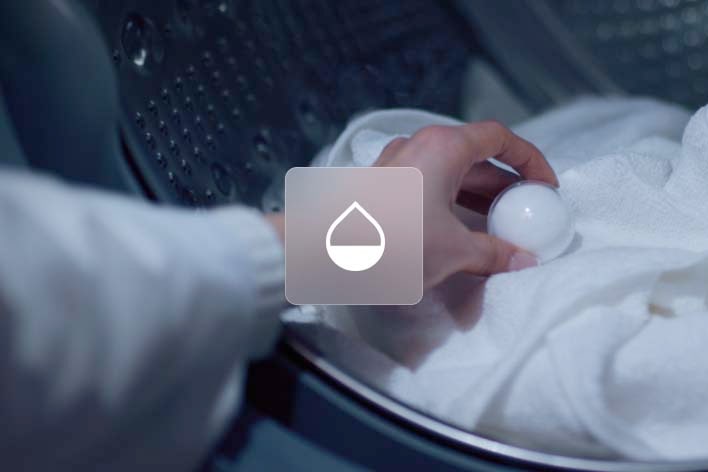Hand placing laundry capsule into washing machine