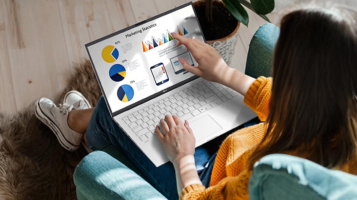 The image shows a person using a laptop while seated comfortably, interacting with the touchscreen to navigate charts and graphs. An animation demonstrates the anti-glare screen by showing no light reflection even when sunlight shines directly onto the display. The image shows a person using a laptop while seated comfortably, interacting with the touchscreen to navigate charts and graphs. An animation demonstrates the anti-glare screen by showing no light reflection even when sunlight shines directly onto the display.